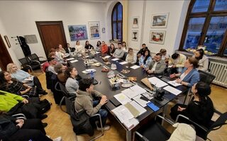 Menschen im Austausch an einem Tisch