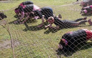 Muddy Angel - Teilnehmerinnen kriechen unter einem Netz entlang