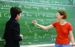 Studentin und Professorin vor Tafel mit Gleichungen