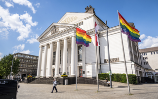 Stadtflagge und Regenbogenflaggen wehen vor dem Stadttheater Duisburg