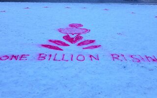 Das LOGO von One Billion Rising mit pinker Sprühfarbe in den Schnee gesprüht