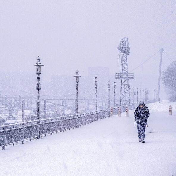 Einsamer Mensch spaziert durchs Schneetreiben