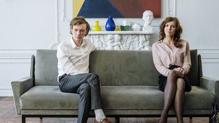 Eine Frau und ein Mann auf einem Sofa bei schlechter Stimmung